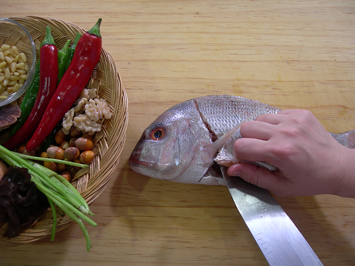 Remove the scales, fins and internal organs of the sea-bream and rinse the carcass. Slice fillets from both sides of the fish. 