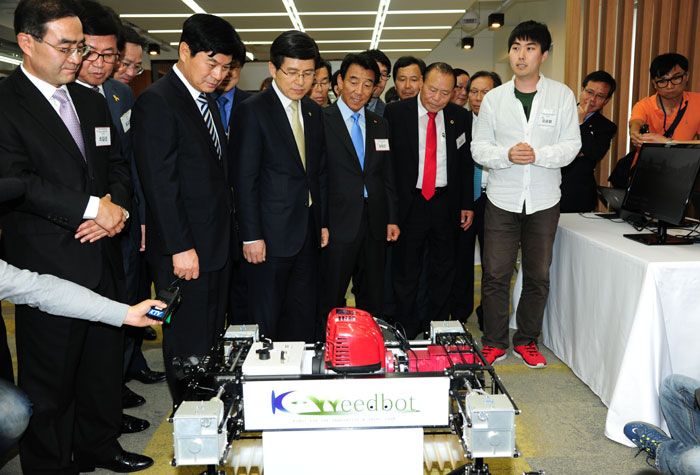 세종창조경제혁신센터에서 참석자들이 무인 로봇 제초기를 살펴보고 있다.