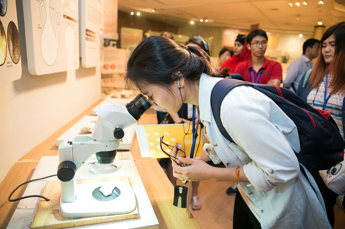 한 참가자가 현미경으로 도자기의 표면을 관찰하고 있다.
