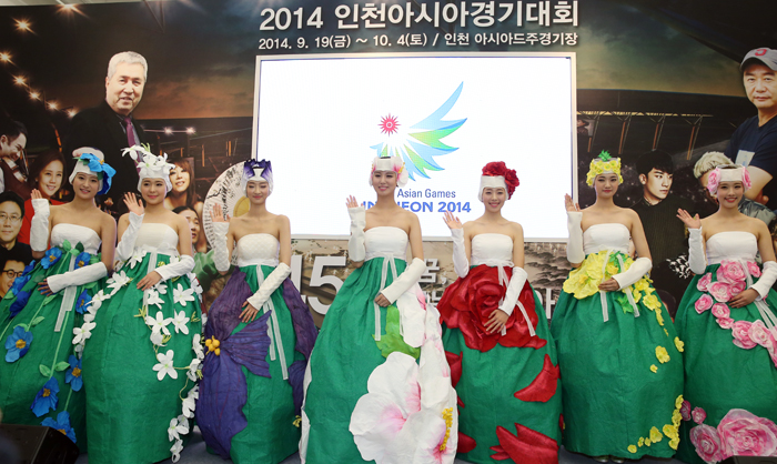 2014 인천 아시아경기대회 개막식 피켓요원 의상을 선보인 모델들이 손을 흔들며 인사하고 있다.