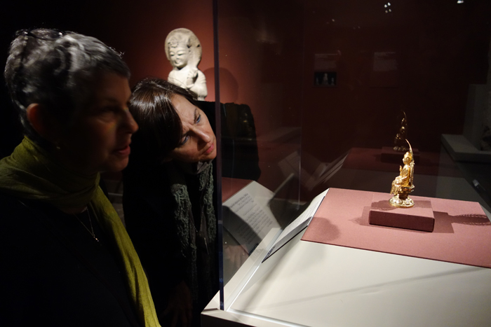 Visitors admire a golden seated Buddha. (photo courtesy of the National Museum of Korea)