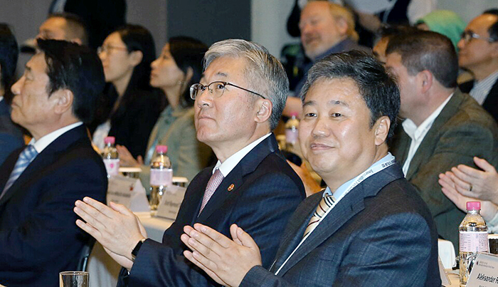Minister of Culture, Sports and Tourism Kim Jongdeok (left) and Jung Kyu-sung, president of the Journalists Association of Korea, applaud during the opening ceremony of the fourth Journalist Forum for World Peace on April 18 in Seoul.