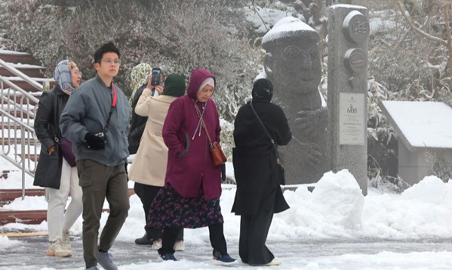 السياح الأجانب يزورون جبل هالا في جيجو المغطى بالثلوج