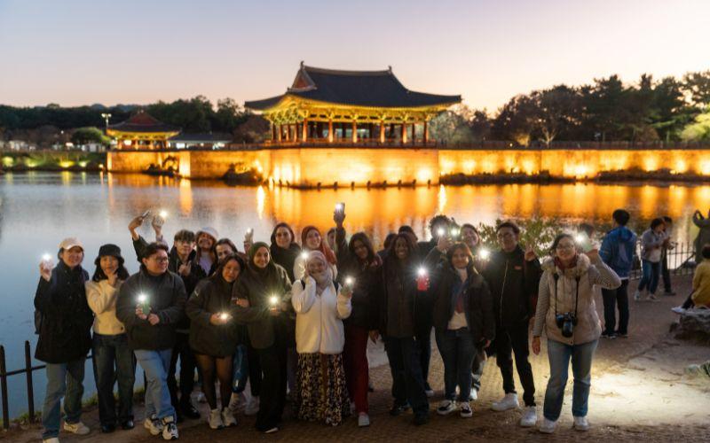 صورة لمجموعة جولة كوسيس الثقافية 2023 من أفضل المراسلين الفخريين وكي-أنفلونسرز وفائزي توك توك كوريا من أمام قصر دونغجونغ و بحيرة وولجي. (الصورة من كوسيس)