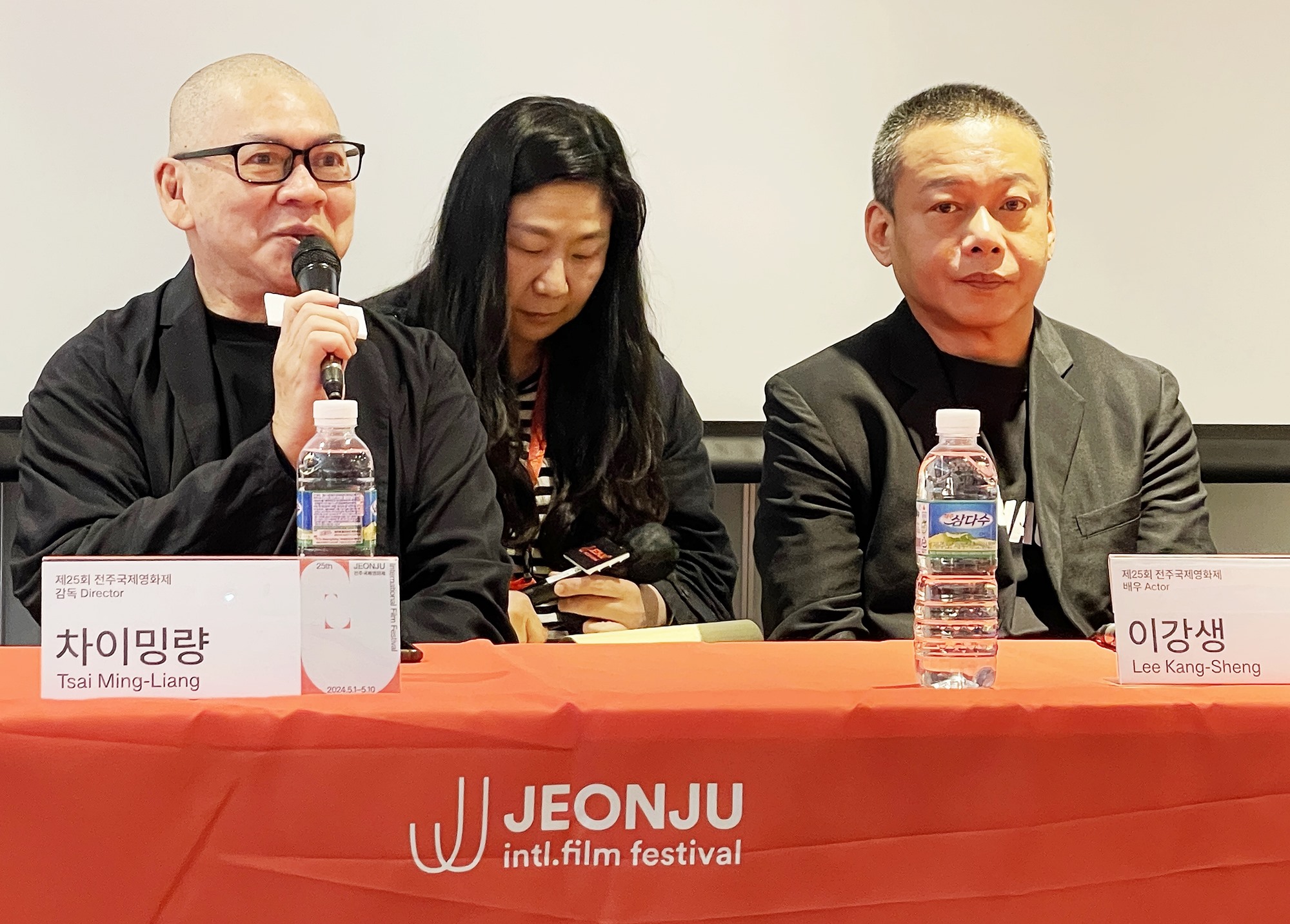 المخرج التايواني تساي مينغ ليانغ (على اليسار) يجيب على أسئلة الصحفيين خلال المؤتمر الصحفي للمعرض الخاص ’سلسلة ووكر‘ على هامش الدورة الـ25 من مهرجان جيونجو السينمائي الدولي الذي أقيم في فندق بيست ويسترن بلس جيونجو في حي وانسان بمدينة جيونجو، مقاطعة جولا الشمالية في يوم 3 مايو.