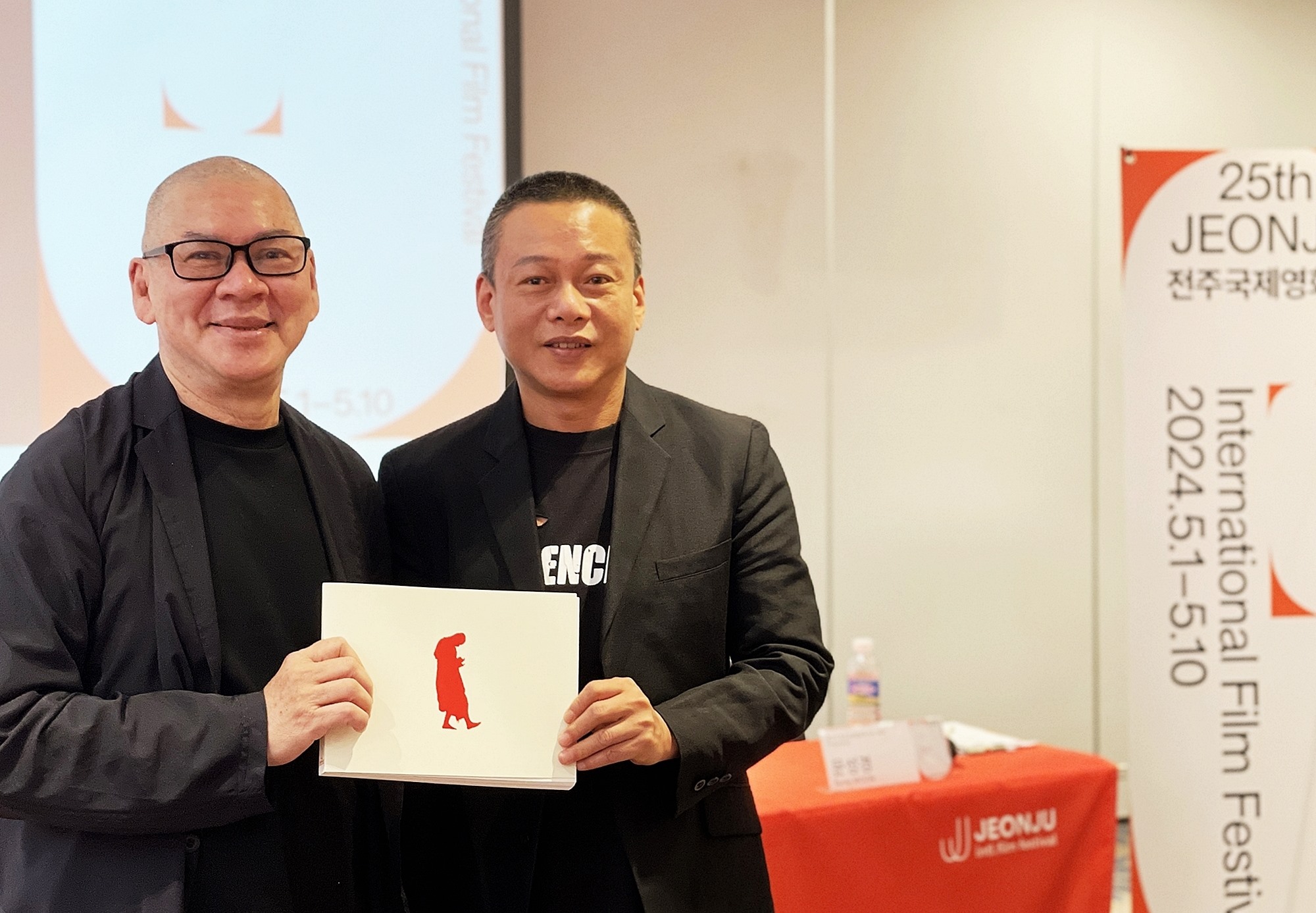 المخرج التايواني تساي مينغ ليانغ (على اليسار) والممثل التايواني لي كانغ-شنغ يلتقطان صورة تذكارية وهما يحملان دليل برنامج للمعرض الخاص ’سلسلة ووكر‘ خلال المؤتمر الصحفي على هامش الدورة الـ25 من مهرجان جيونجو السينمائي الدولي الذي أقيم في فندق بيست ويسترن بلس جيونجو في حي وانسان بمدينة جيونجو، مقاطعة جولا الشمالية في يوم 3 مايو.