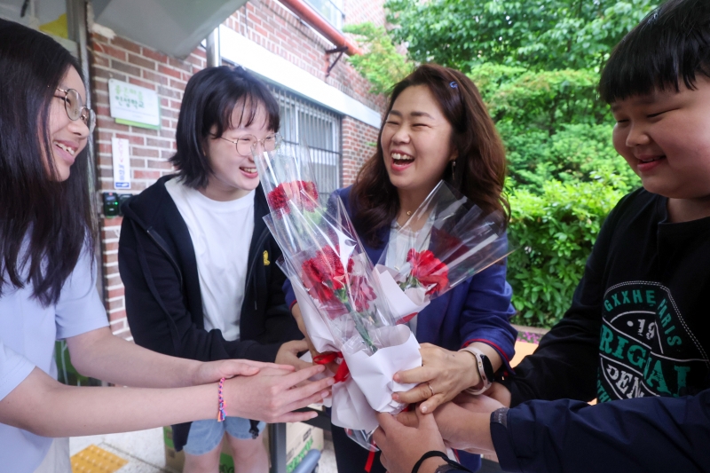 معلمة تتلقى زهور القرنفل من الطلاب في مدرسة دونغيل الابتدائية الواقعة بحي نوون، سيئول في يوم المعلم الموافق 15 مايو.