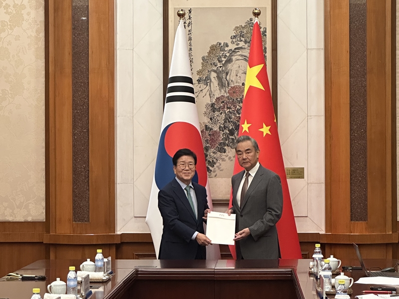 رئيس الجمعية الوطنية السابق بارك بيونغ-سوك (على اليسار) يسلم رسالة شخصية من الرئيس لي جيه-ميونغ إلى الرئيس الصيني شي جين بينغ خلال اجتماعه مع وزير الخارجية الصيني وانغ يي في بكين يوم 24 أغسطس. (الصورة من وزارة الخارجية)