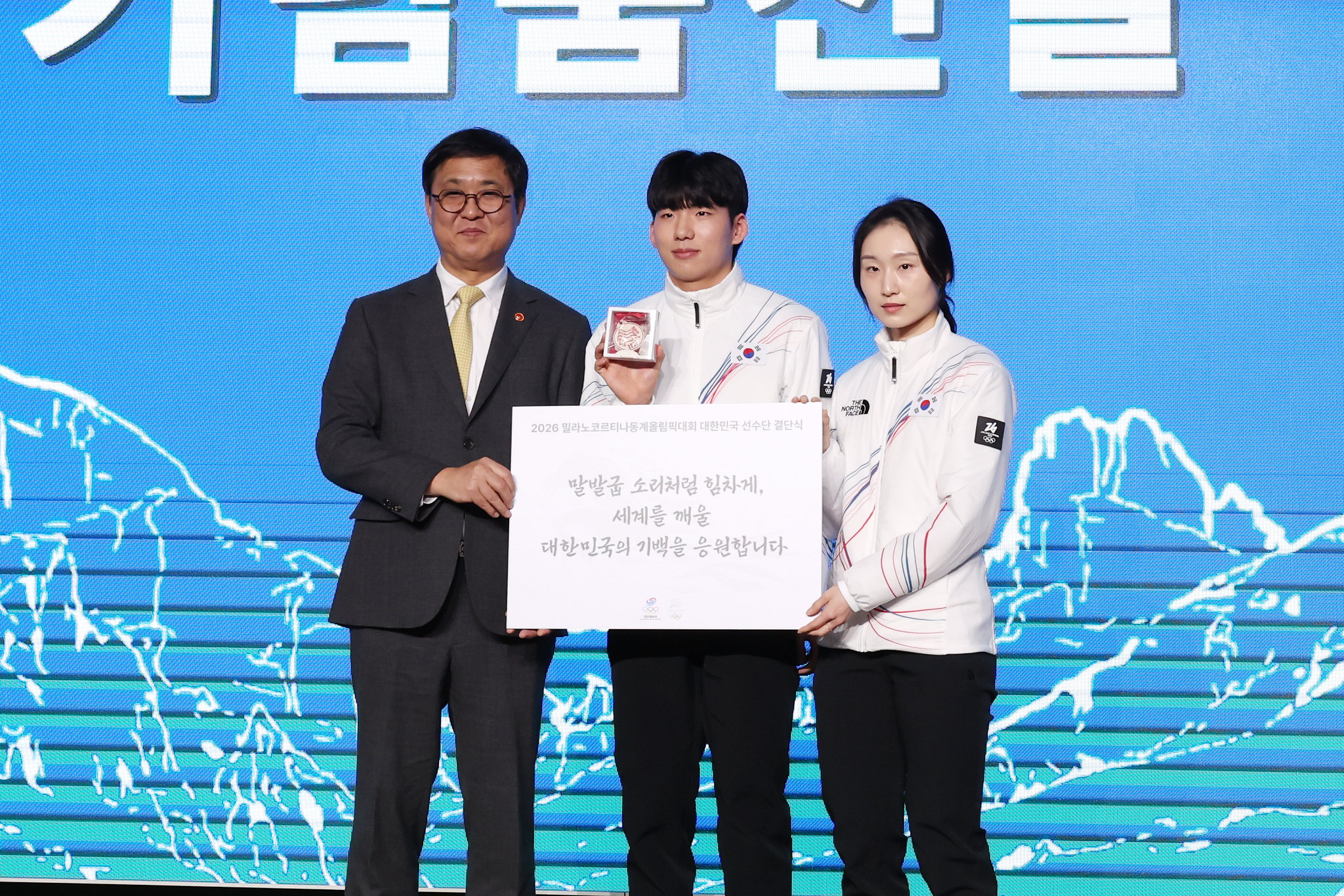 وزير الثقافة والرياضة والسياحة تشوي هوي-يونغ (على اليسار) يلتقط صورة تذكارية مع الرياضيين جيونغ جيه-وون (في الوسط) وتشوي مين-جيونغ خلال حفل إطلاق البعثة لدورة الألعاب الأولمبية الشتوية ميلانو كورتينا 2026، في سيئول في 22 يناير.