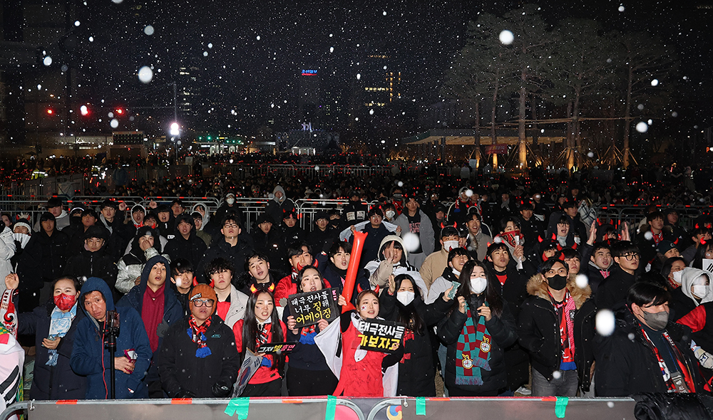 2022 카타르 월드컵 16강전 대한민국과 브라질의 경기가 열린 6일 오전 서울 종로구 광화문 광장에서 시민들이 눈을 맞으며 응원하고 있다. 연합뉴스
