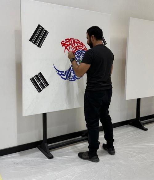 مرحلة رسم علم كوريا 'تاي غوك كي' مع دمجها بحروف اللغة العربية واستخدام فن الكاليجرافي لتشجيع فريق كوريا في مبارياته في كأس العالم لكرة القدم في قطر عام 2022 ويظهر بها الفنان ضياء علام أثناء رسمها.