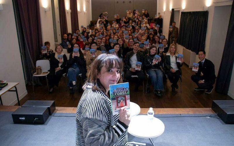 الصورة تظهر الكاتبة ماريانا بارولي مع الجمهور من ترويجات لكتاب كوريا من الألف إلى الياء.