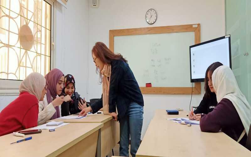 المعلمة بارك هانيه برفقة طلابها أثناء تكليفهم بتدريب لتساعدهم إذا واجهوا اي صعوبة أثناء الحل. (الصورة من المراسلة منةاللّه منصور)