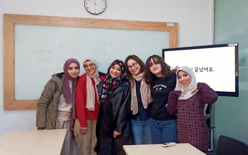 المعلمة بارك هانيه برفقة طلاب فصل تعلم اللغة الكورية من خلال الكي بوب بعد انتهاء المحاضرة. (الصورة من المراسلة منةاللّه منصور)
