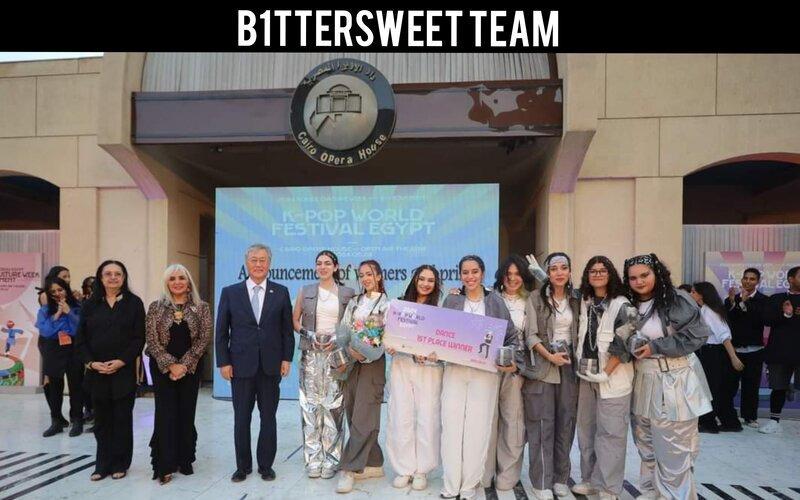 الصورة تظهر فريق بيترسويت أثناء الحصول على جائزة المركز الأول عن فئة الرقص في مسابقة كيبوب وورلد فيستيفال ٢٠٢٤، ويظهر في الصورة سعادة سفير جمهورية كوريا في مصر السيد كيم يونج-هيون إلى جانب أعضاء لجنة التحكيم. (الصورة من الصفحة الرسمية للمركز الثقافي الكوري بمصر على الفيسبوك)