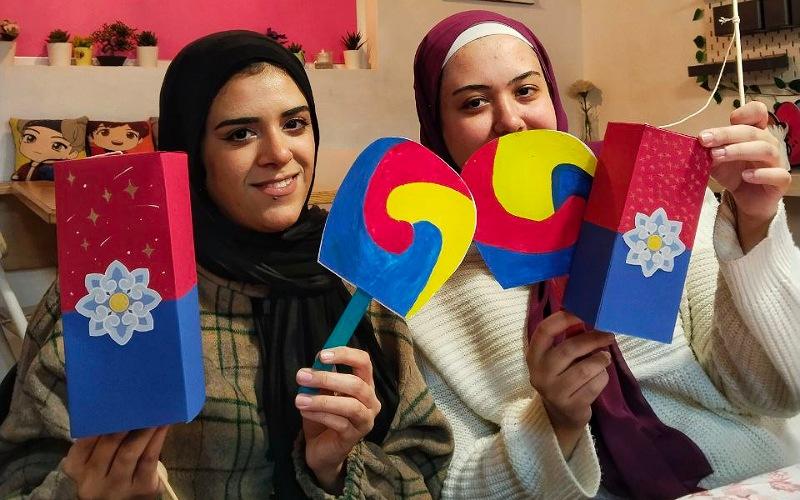 تظهر الصورة إلهام وشقيقتها أثناء حضورهم ورشة 