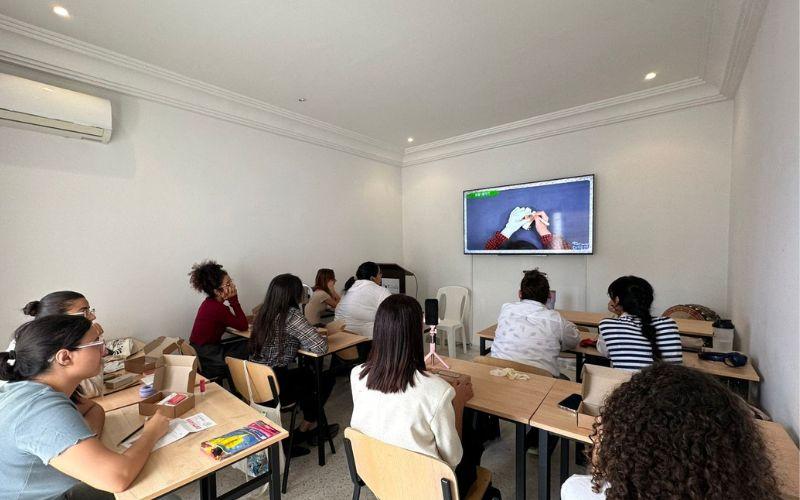 صورة من حصة الفنون اليدوية في معهد الملك سيجونغ بتونس، يظهر فيها المشاركون وهم يشاهدون فيديو تعليمي يشرح خطوات صنع الطابع الكوري. (الصورة من معهد الملك سيجونغ بتونس وتم الحصول على الإذن لاستخدامها)