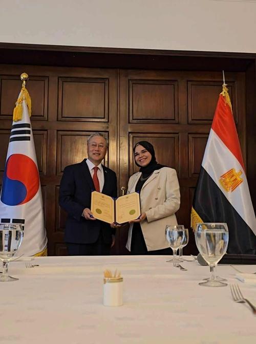 صورة الشيف ندى الباشتلي مع السفير الكوري في مصر السيد كيم يونج هيون لاستلامها شهادة السفير الرقمي في مصر بالسفارة الكورية بمصر. (الصورة من ندى الباشتلي وتم أخذ الإذن بنشرها)