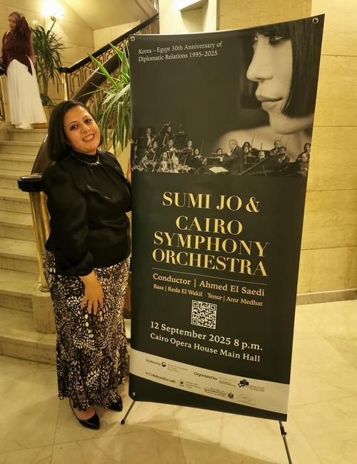 صورة لي بجوار لافتة الإعلان عن حفل الفنانة ’جو سومي‘ وأوركسترا القاهرة السيمفوني بدار الأوبرا. (الصورة من أمنيه أمير)
