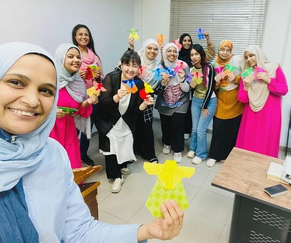 صورة للمشاركين بالورشة مع المدربة إم سورا بعد انتهاء الورشة وكلًا منهم ممسكًا بنموذج الهانبوك الذي صنعوه. (الصورة من زينب نيازي حسن)