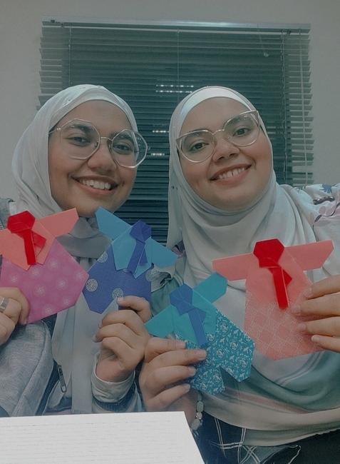 صورة لي مع اختي بعد انتهاء الورشة ونحن نمسك نماذج الهانبوك التي صنعناها بأنفسنا. (الصورة من زينب نيازي حسن)