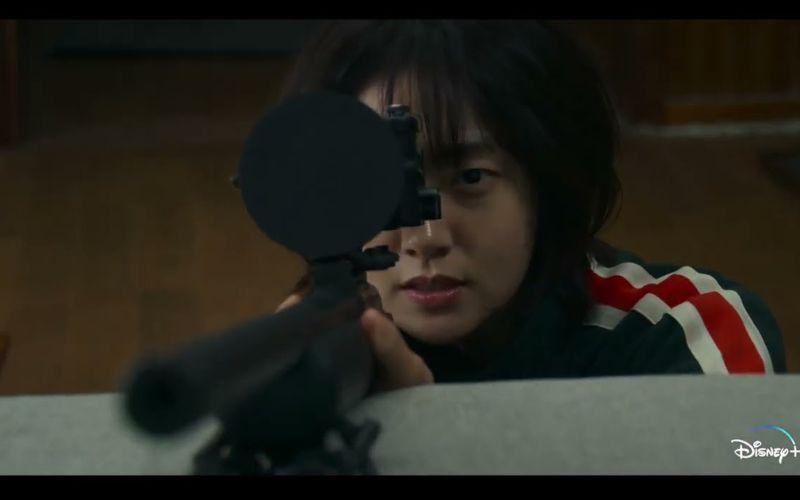 لقطة من مسلسل متجر للقتلة تظهر بها شخصية جونغ جي آن وهي تحمل سلاحا. (تعود حقوق الصورة إلى منصة 'ديزني')