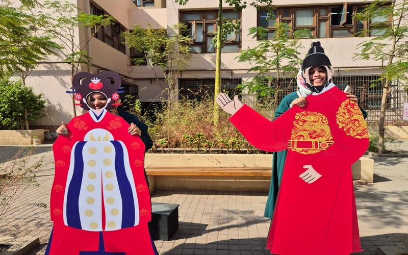 صورتي مع إحدى زميلاتي خلف مجسمات الملوك والملكات الكوريين بالزي التقليدي الكوري في ساحة الكلية (الصورة من ياسمين مدحت.)