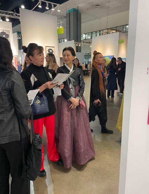 الفنانة الكورية سو أون جين تشرح للحضور لوحاتها. (الصورة من الفنانة سو أون جين وتم أخذ الإذن لاستخدامها.)