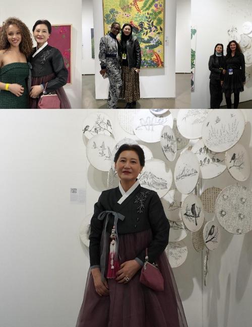 سو أون جين بالهابوك الكوري في لوس أنجلوس وبين أصدقائها ولوحاتها. (الصورة من الفنانة سو أون جين وتم أخذ الإذن لاستخدامها.)