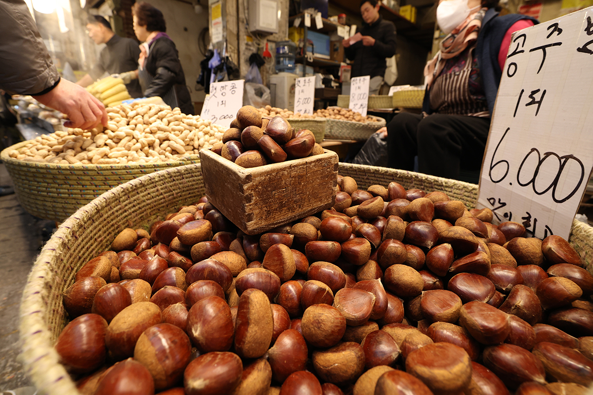 تاجر يبيع المكسرات التي تُؤكل في أول بدر من السنة القمرية المعروف باسم &rsquo;ديبوروم&lsquo;، مثل الكستناء والجوز والصنوبر، في سوق غيونغدونغ التقليدي بحي دونغديمون-غو في سيئول في 3 مارس. جرت العادة أن يُصلي الناس من أجل الصحة ووفرة المحاصيل في ذلك الوقت.