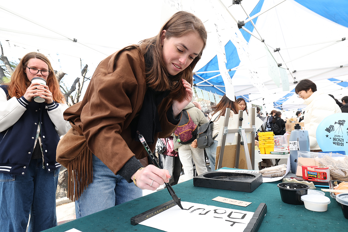 طالبة أجنبية تجرّب فن الخط الكوري داخل جناح الترويج لنادي الخط خلال معرض الأندية الذي أُقيم في جامعة آجو بمدينة سوون التابعة لمقاطعة غيونغغي في يوم 4 مارس، تزامنًا مع انطلاق الفصل الدراسي الجديد.