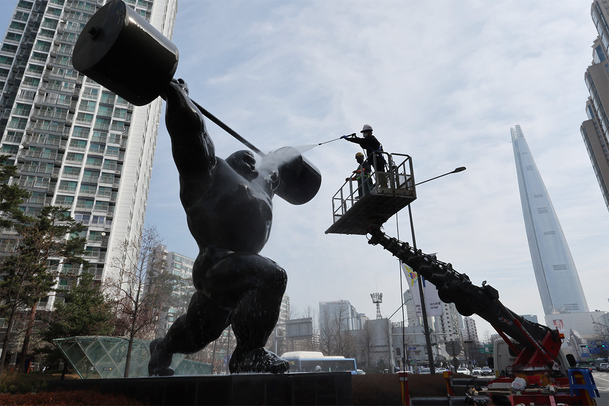 عمال يرشون الماء على تمثال لرافع أثقال بالقرب من الطريق الأولمبي في منطقة سونغبا-غو بسيئول في 25 مارس لتنظيفه في بداية فصل الربيع. ويعد هذا التمثال واحدا من التماثيل لتخليد ذكرى استضافة كوريا لدورة الألعاب الأولمبية الصيفية في عام 1988.