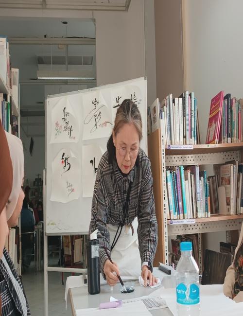 صورة للمعلمة أثناء شرح كيفية استخدام الفرش من الحصة الأولى. (الصورة من المراسلة سنية محمود حسين)