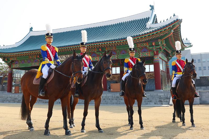 اصطفافٌ مهيب لطلاب الأكاديمية وخيولهم في ميدان 'هوارانغ'؛ (من اليسار: كيم كوان-هونغ (السنة الرابعة)، وجانغ وون هيوك (السنة الثالثة)، ويون هيو-رين (السنة الثانية)، وهو جون-سوك (السنة الرابعة). هنا، تتجسد سطوة الفرسان التي تميزت بها معارك الماضي كإرثٍ رمزي يخلد روح الأكاديمية العسكرية الكورية. ورغم تحول دورها القتالي، لا يزال الانضباط والعزيمة الكامنان في جوهرها ينبضان بالحياة بصورة معاصرة، حيث تتجاوز وحدة الخيالة الفعاليات الداخلية المقامة في الأكاديمية لتشارك في الفعاليات الخارجية، وتمدد جسور التواصل والاعتزاز مع أبناء الشعب. 