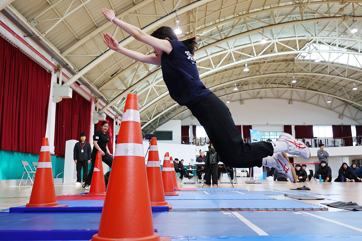 فتاة ترغب في العمل في سلطة الإطفاء تقوم بحركة الوثب الطويل من وضع الثبات خلال اختبار القدرات البدنية لهذا العام في مدينة إنتشون، غرب سيئول، في 1 أبريل.