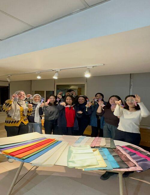 صورة جماعية لكل المشاركين بالورشة حاملين ما قاموا بعمله من نوريغي وفواصل الكتب- (الصورة من أمنيه أمير)