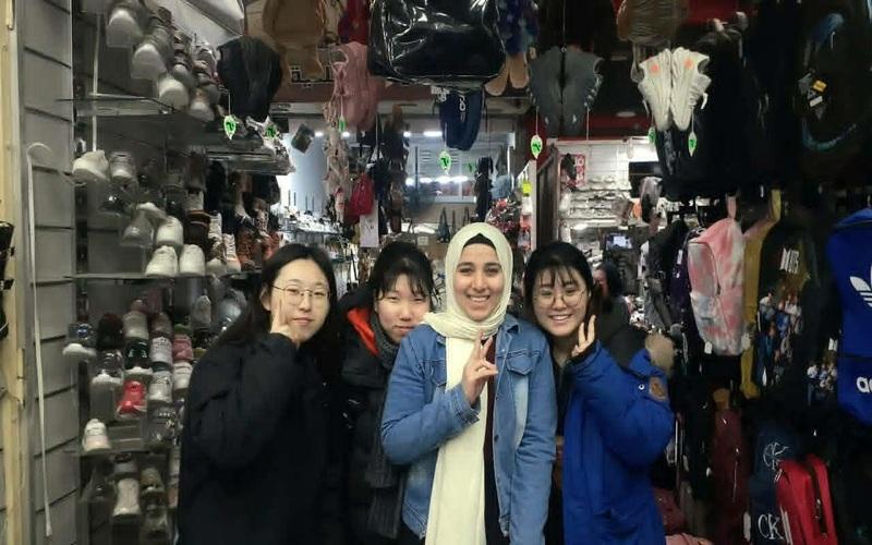 لقطة تجمع شروق أيمن مع ثلاث فتيات كوريات يبتسمن ويرفعن علامة النصر أثناء جولة تسوق داخل أحد محلات الحقائب والأحذية في القاهرة عام 2021. (المصدر: شروق أيمن)