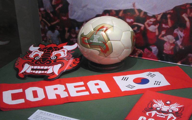 مقتنيات تذكارية من كأس العالم 2002 معروضة في المتحف الوطني للتاريخ الكوري المعاصر في سيئول، تبرز الحماس الجماهيري الذي رافق الإنجاز التاريخي للمنتخب الكوري. (الصورة من إسراء الزيني)