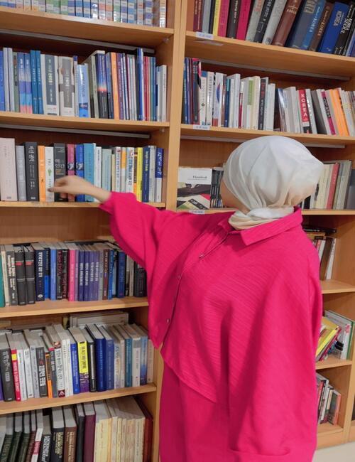 هدير متولي تبحث عن رواية بين رفوف مكتبة المركز الثقافي الكوري في مصر. (المصدر: هدير متولي)